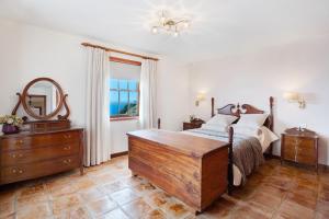 um quarto com uma cama, uma cómoda e um espelho em Casa 1700 Los Quemados em Los Quemados