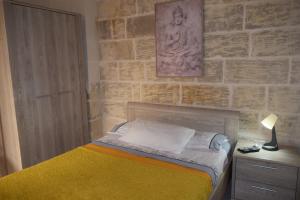 um quarto com uma cama e uma parede de tijolos em St George of Lydda B&B em Victoria