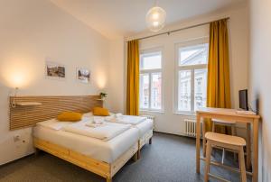 1 dormitorio con 2 camas, escritorio y ventana en Self-service Hotel Ostaš Praha en Praga