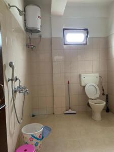 a small bathroom with a toilet and a window at Enchanting Tawang in Tawang