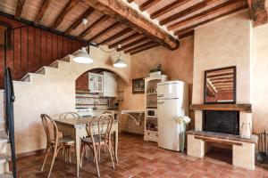 a kitchen with a table and chairs and a refrigerator at Appartamento La Roccaia in San Gimignano