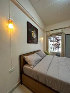 1 dormitorio con 1 cama con reloj en la pared en 66 Apartment en Ban Khlong Nong Yai