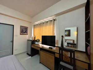 a room with a desk with a television on it at 66 Apartment in Ban Khlong Nong Yai
