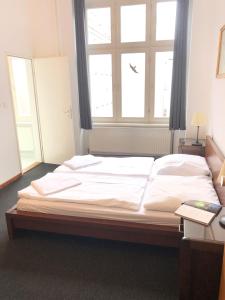 Bett in einem Zimmer mit einem großen Fenster in der Unterkunft Die Fabrik - baxpax Hotel in Berlin