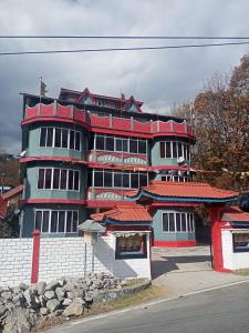 達旺鎮的住宿－Enchanting Tawang，街道上一座红色屋顶的大型建筑