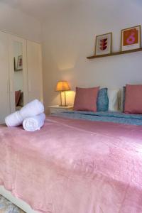 Una cama rosa con dos almohadas encima. en Fuerteventura Beach Vacations, en Puerto del Rosario