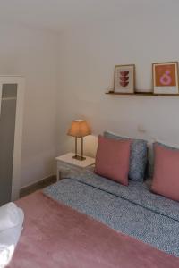a bedroom with a bed with red and blue pillows at Fuerteventura Beach Vacations and Blue Mango surf&fitness center at charco in Puerto del Rosario