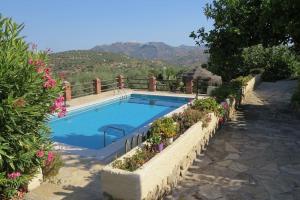una piscina con plantas y flores a su alrededor en La Molina Del Olivar - Peaceful Location, en Ríogordo