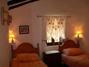 sypialnia z dwoma łóżkami i oknem w obiekcie La Molina Del Olivar - Peaceful Location w mieście Ríogordo