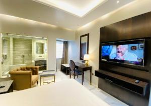 Cette chambre d'hôtel dispose d'une grande télévision à écran plat. dans l'établissement Prayag Inn, à Allahābād