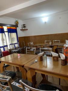 a room with wooden tables and chairs and tables and chairs at Enchanting Tawang in Tawang