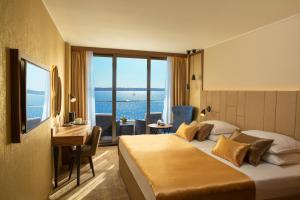 um quarto de hotel com uma cama, uma secretária e uma janela em Grand Hotel Bernardin em Portorož