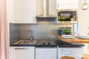 una cucina con lavandino e piano cottura forno superiore di Cosy Studio - 2P- Beauregard - 3 a Parigi