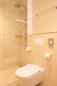 a bathroom with a toilet and a glass shower at Grand Hotel Bernardin in Portorož