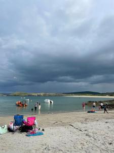 um grupo de pessoas numa praia perto da água em Beach View Portnablagh Dunfanaghy em Dunfanaghy