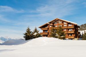 Un bâtiment dans la neige devant dans l'établissement Lagrange Vacances Le Village des Lapons, aux Saisies