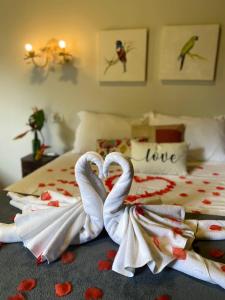 dos cisnes envueltos en toallas sentadas en una cama en Pousada Cheiro de Mato en Bonito