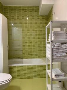諾瓦萊斯的住宿－los laureles de novales，绿色浴室设有浴缸、卫生间和毛巾。