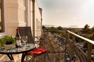 einen Tisch mit einem Glas Wein auf dem Balkon in der Unterkunft Villa Seeblick Warnemünde - Fewo mit Meerblick und Balkon direkt am Strand für 2-4 Pers in Rostock