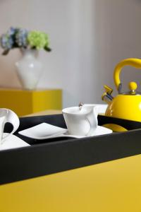 a table with two white cups and a yellow tea kettle at Palazzetto de Lante Appartamento Pinta in Rome