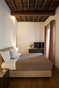 een slaapkamer met een groot bed en een raam bij Palazzetto de Lante Appartamento Pinta in Rome