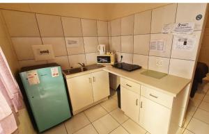 a small kitchen with a refrigerator and a sink at Sheilas Self-Catering Overnight Accommodation in Polokwane