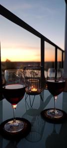 3 verres de vin assis sur une table au coucher du soleil dans l'établissement Apartament Skorpion Marina & Spa Sagaris Dziwnów, à Dziwnów