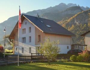 a large white building with a flag next to a fence at mountain-panorama EG 2-Bettwohnung in Meiringen