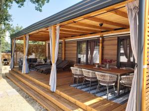 una terraza de madera con mesa y sillas en Mobile Home Sole en Biograd na Moru
