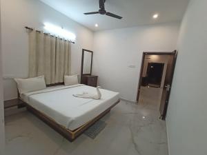 a bedroom with a bed and a ceiling fan at Sushmika Villas in Yercaud