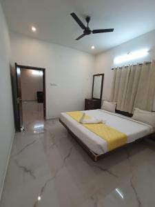 a bedroom with a bed and a ceiling fan at Sushmika Villas in Yercaud