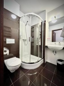 a bathroom with a shower and a toilet and a sink at Hotel Szyndzielnia Eco in Bielsko-Biała