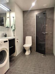 y baño con ducha, aseo y lavamanos. en Fully Equipped New Apartment With Free Parking en Tampere