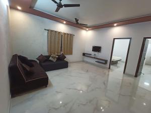 a living room with a couch and a television at Sushmika Villas in Yercaud