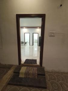 a mirror in a room with a rug in front at Sushmika Villas in Yercaud