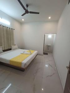 a bedroom with a bed and a ceiling fan at Sushmika Villas in Yercaud