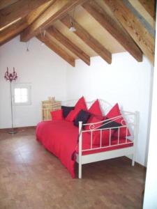 uma cama vermelha com almofadas vermelhas num quarto branco em mountain-panorama DG 4-Bettwohnung em Meiringen