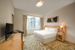 una camera con letto e TV a schermo piatto di Oaks Liwa Heights Hotel Suites a Dubai