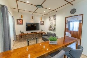 邦勞的住宿－Alona Apartments，客厅配有木桌和电视。