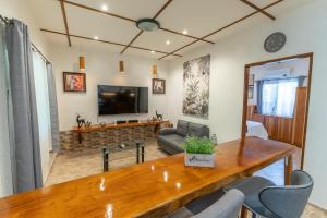 a living room with a wooden table and a tv at Alona Apartments in Panglao