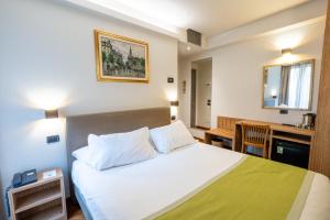 een hotelkamer met een bed en een bureau bij Hotel Regina in Milaan