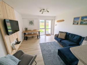a living room with a blue couch and a tv at No.7 Perran View in St. Agnes 