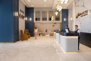 迪拜Oaks Liwa Heights Hotel Suites的大堂里有人在电脑上工作 更多28张照片