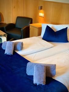 two beds in a hotel room with blue pillows at Hotel La Ferté in Stuttgart