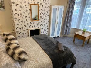 a bedroom with a bed with a fireplace and a mirror at Salisbury House in Kettering