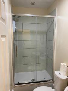 a glass shower in a bathroom with a toilet at Salisbury House in Kettering