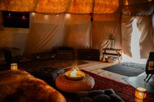 een woonkamer met een kaars op een tafel bij Lapiland - off-grid yurts & tipis - the place to reconnect with nature 