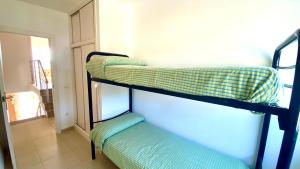 three bunk beds in a room with a window at Duplex Ancla in L'Ametlla de Mar