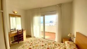 a bedroom with a bed and a large window at Duplex Ancla in L'Ametlla de Mar