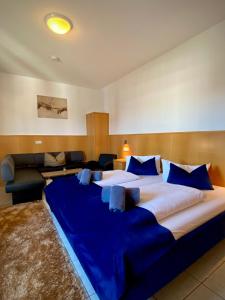 Hotel La Ferté في شتوتغارت: سرير كبير مع ملايات زرقاء في الغرفة